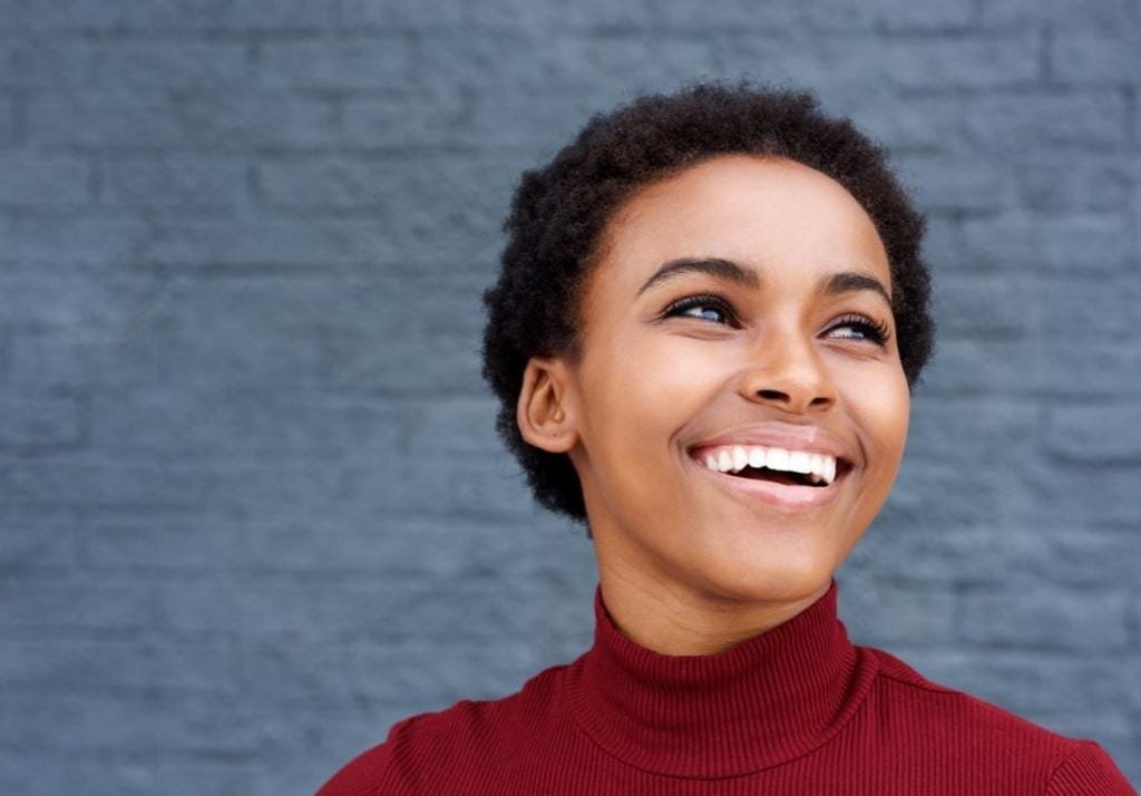 close up happy young black woman laughing WQX59HA