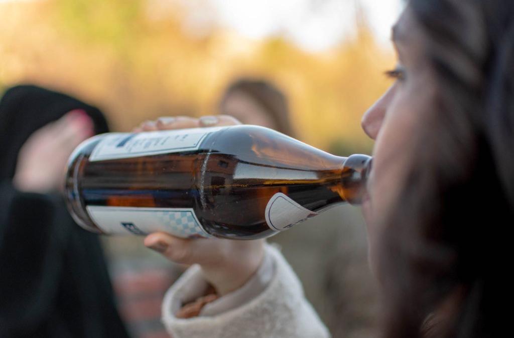 teen drinking close up selective focus image of young woman holding bottle of beer person drinking beer at a party t20 R0jdNv