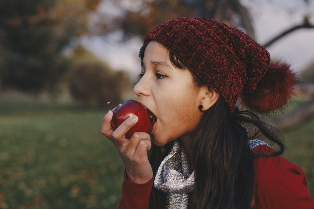 teen teeth health a young girl taking a bite of an apple t20 4b1J38
