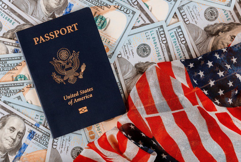 patriotic usa passport on top of a pile of one hundred us banknote currencies on american flag t20 jRWYBr