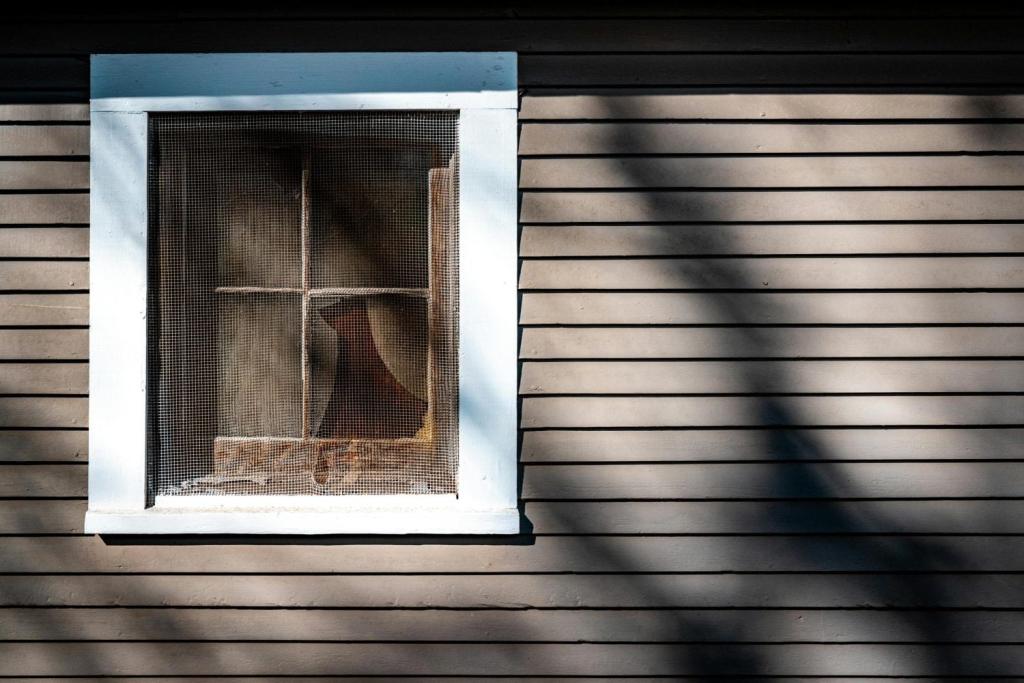 free photo of wall of a house with a window covered with net scaled