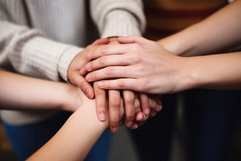 a photorealistic iphoen phot, grainy of a pair of hands grabbing another pair of hands in surpport, as if two females are consoling each other. do not add extra fingers